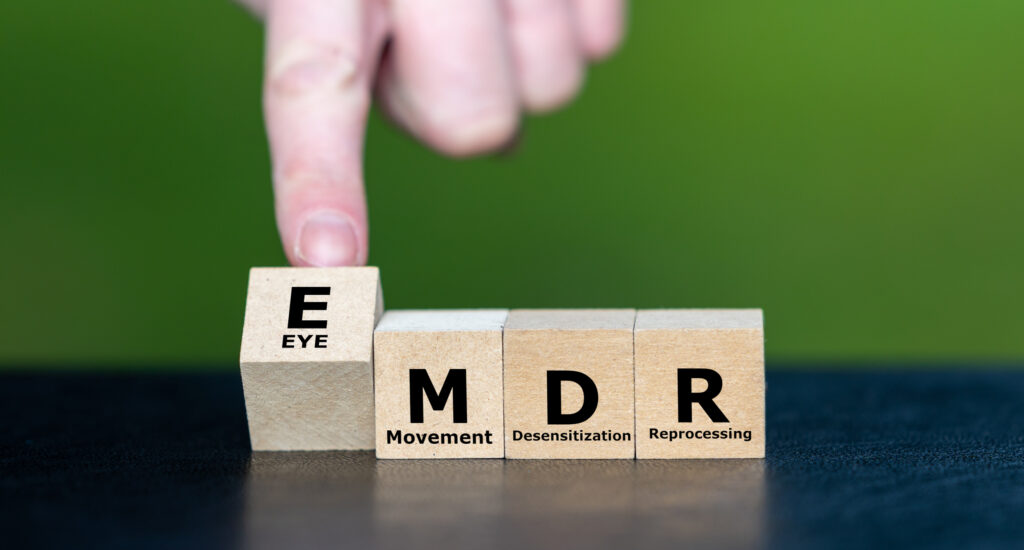 Kubussen vormen de expressie EMDR, wat staat voor Eye Movement Desensitization and Reprocessing. EMDR is een psychotherapeutische behandeling die is ontworpen om de pijn te verlichten die gepaard gaat met traumatische herinneringen.